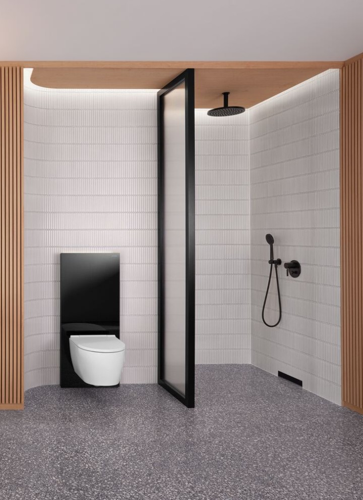 Et bad med trevegg og dusj- og toalett-område i svart og hvitt