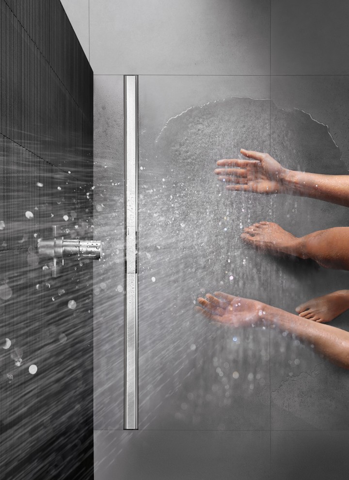 Person som dusjer på en gulvjevn dusjflate utstyrt med Geberit CleanLine-slukrenne