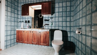 Bad med blå fliser og gulvstående toalett