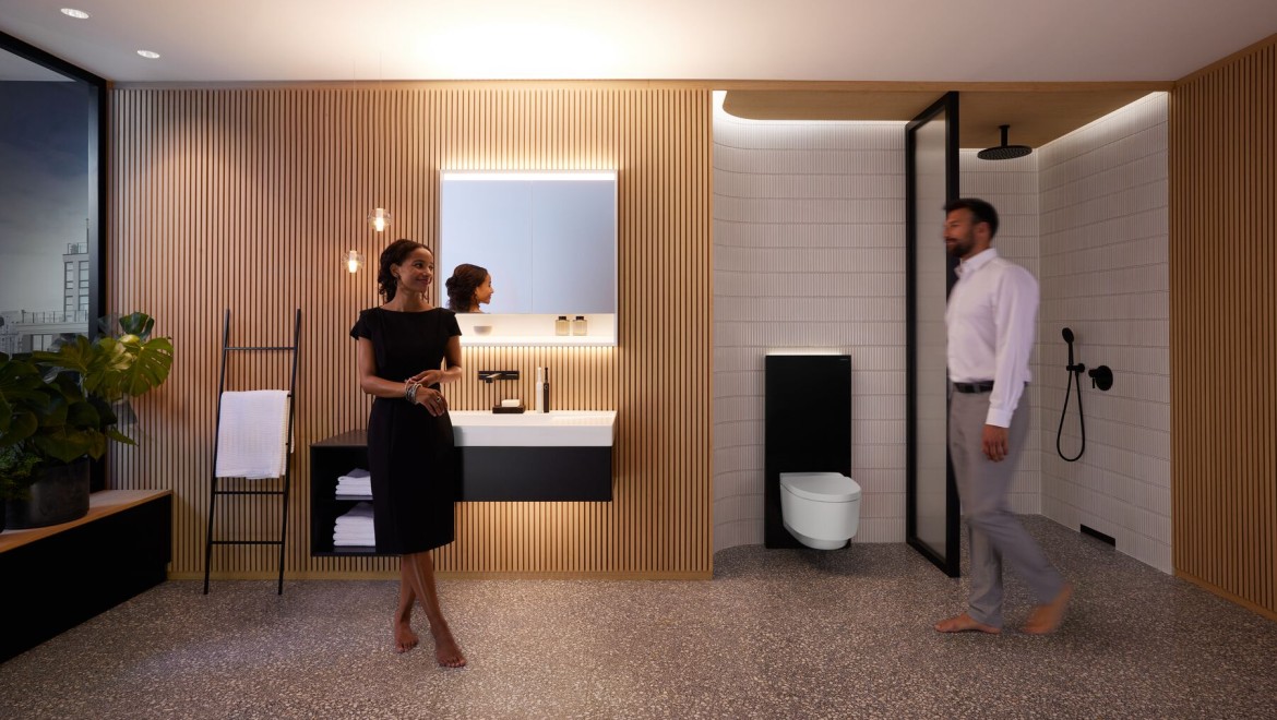 Mann og kvinne i et perfekt opplyst baderom med Geberit ONE-produkter