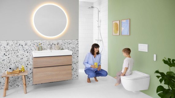 Kvinne og barn på et fargerikt bad med Geberit Option-speil og Geberit AquaClean Alba Kvinne og barn på et fargerikt bad med Geberit Option-speil og Geberit AquaClean Alba