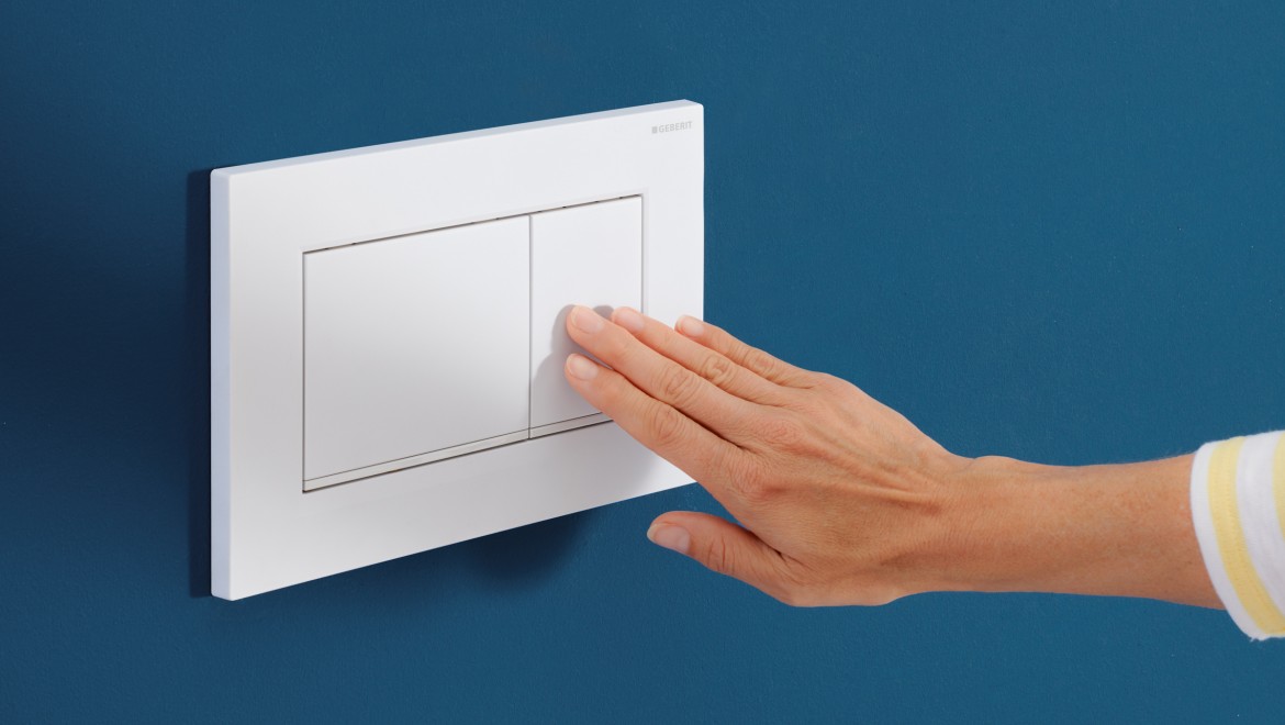 Person presses the small button on the white Sigma30 actuator plate Person presses the small button on the white Sigma30 actuator plate