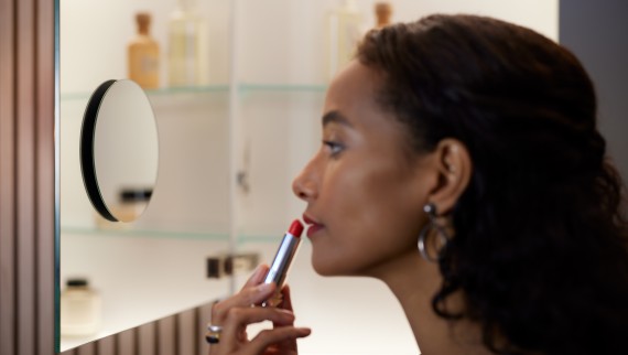 Kvinne med leppestift foran et forstørrelsesspeil (© Geberit)