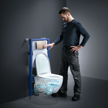 Mann som aktiverer TurboFlush skylleteknologien til et Geberit Acanto toalettet