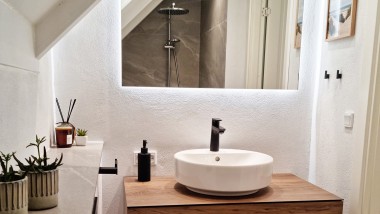 Originalt bad med gulvstående toalett, hvite fliser og baderomsmøbler i tre (© @triner2 og @strandparken3)