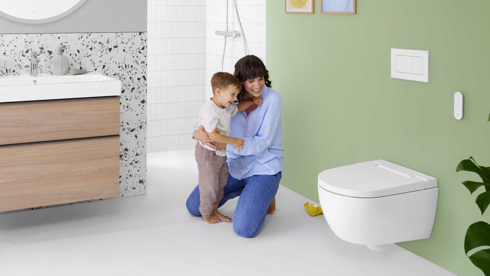 Woman with child in front of a Geberit AquaClean Alba shower toilet