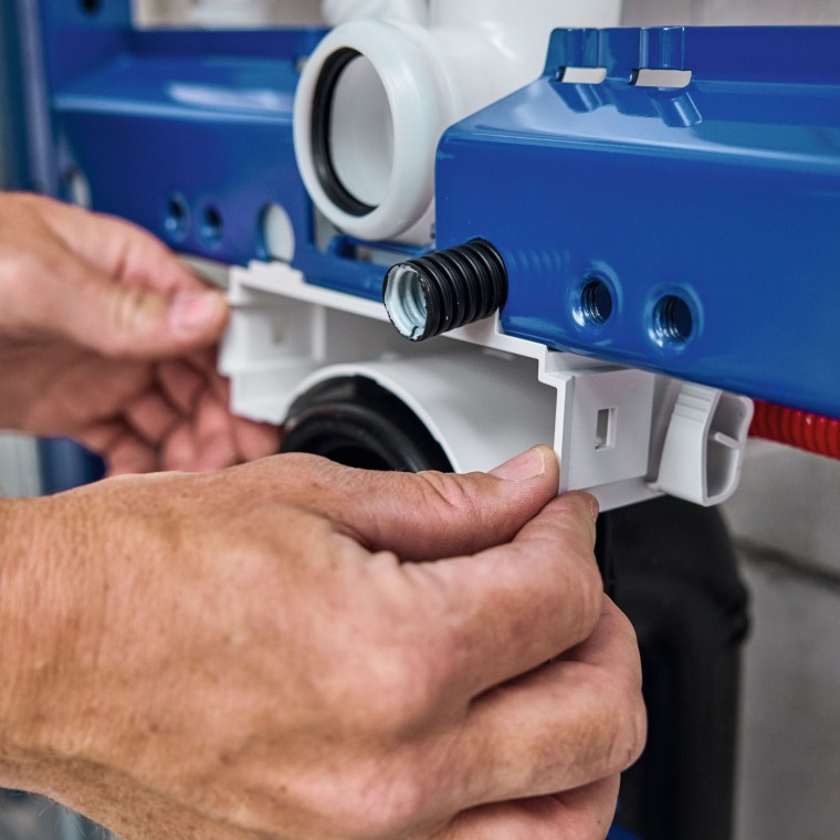 Rørlegger installerer innbyggingssisternen Geberit Power & Connect-boksen