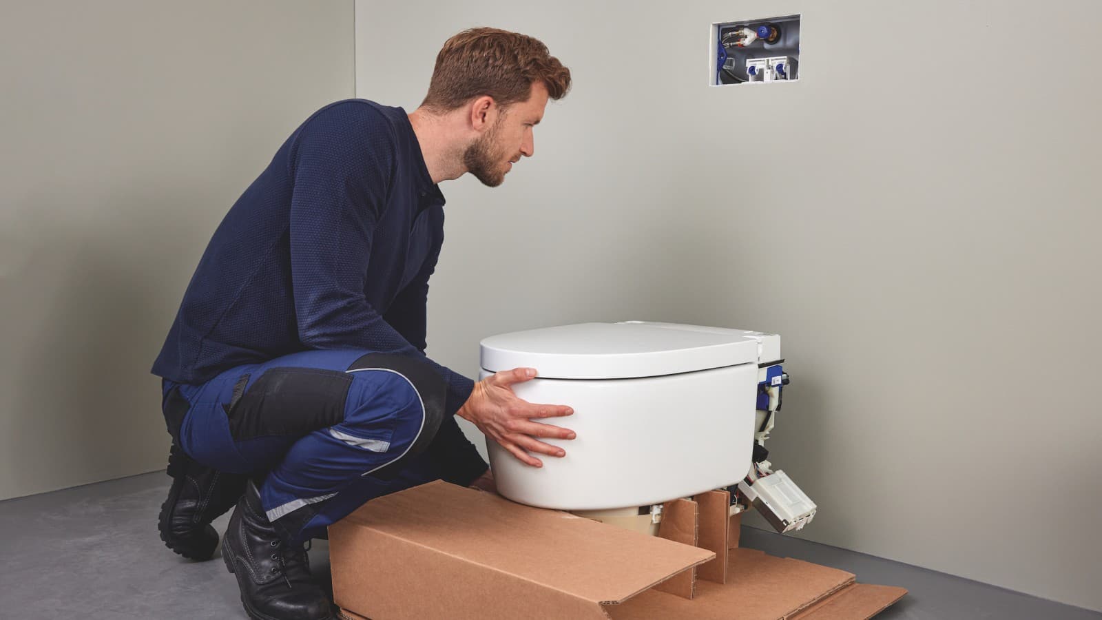 Rørlegger installerer et Geberit AquaClean Sela dusjtoalett Rørlegger installerer et Geberit AquaClean Sela dusjtoalett