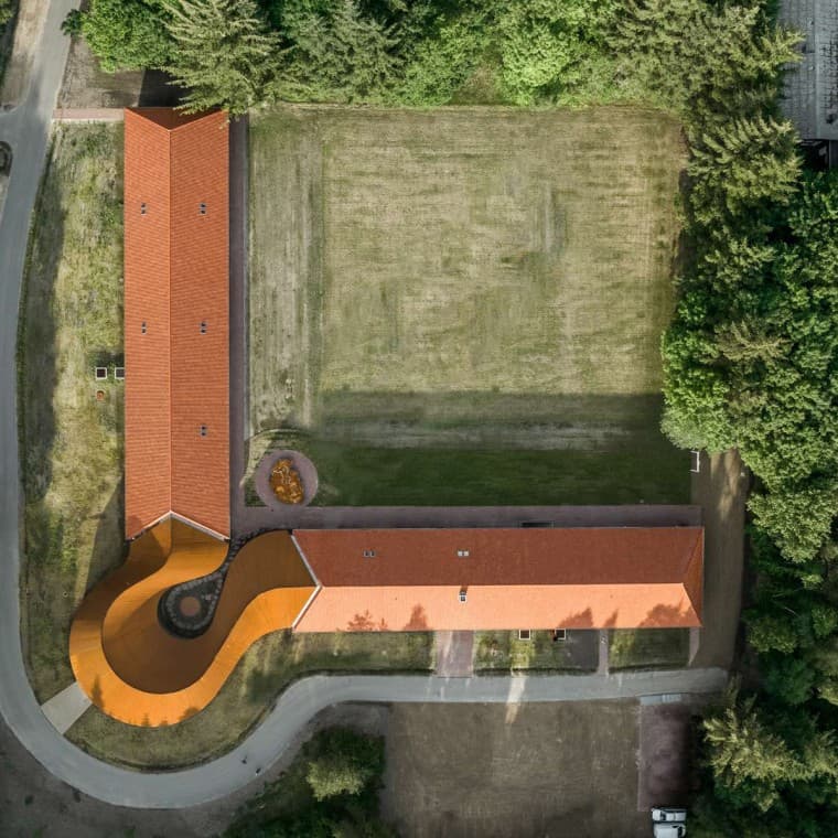 Utsikten ovenfra viser det runde nybygget som forbinder de to historiske bygningene med tegltakene. (© R_Hjortshoj) Utsikten ovenfra viser det runde nybygget som forbinder de to historiske bygningene med tegltakene. (© R_Hjortshoj)